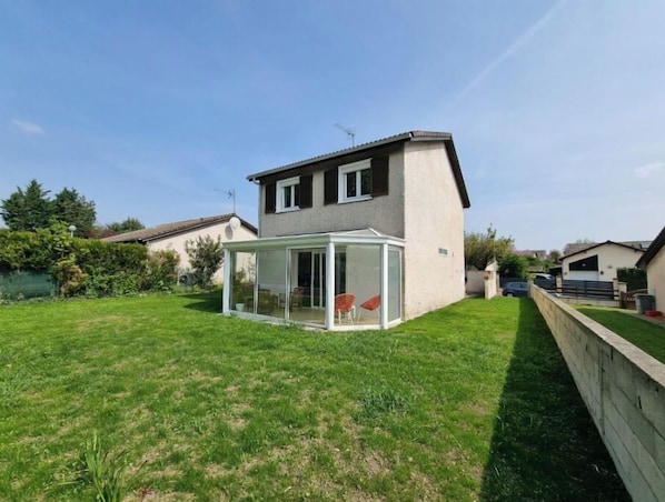 A house with a glass-enclosed patio area.
