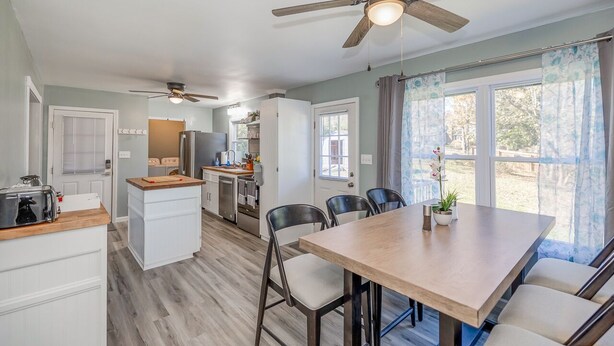 A compact kitchen with a central island, a dining area with a table and chairs, and a ceiling fan. - Cozy Home off I-85, 35 minutes from NC and SC border (Spartanburg)