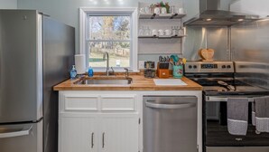 A modern kitchen with stainless steel appliances, a wooden countertop, and a window providing a view of the outdoors. - Cozy Home off I-85, 35 minutes from NC and SC border (Spartanburg)