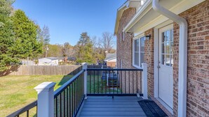A wooden deck with a metal railing, a brick building with a white door, and a welcome mat. - Cozy Home off I-85, 35 minutes from NC and SC border (Spartanburg)