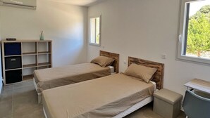 Een slaapkamer met twee bedden, een bureau en een boekenkast.