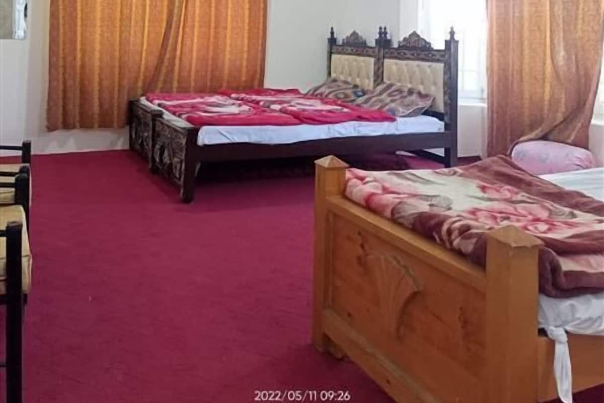 Ein Schlafzimmer mit zwei Betten, einem Deckenventilator und Vorhängen.