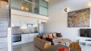 Een modern appartement met keuken, eethoek en woonkamer.