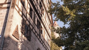 Un bâtiment historique doté de poutres apparentes et d’une façade en pierre.