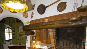 A rustic kitchen with a brick oven, hanging pots, and a wooden beam ceiling. - Moon Nest - Apartment in villa, 10 min from the sea private garden pool (Massarosa)