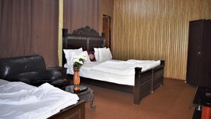 Een hotelkamer met een bed, een stoel, een kaptafel en een kledingkast.