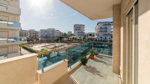 A modern apartment with a glass balcony overlooking a cityscape. - Casa ChiaLù by MONHOLIDAY (Monopoli)