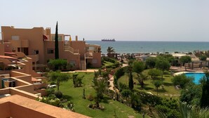 Un resort con piscina, vegetación y vista al mar.