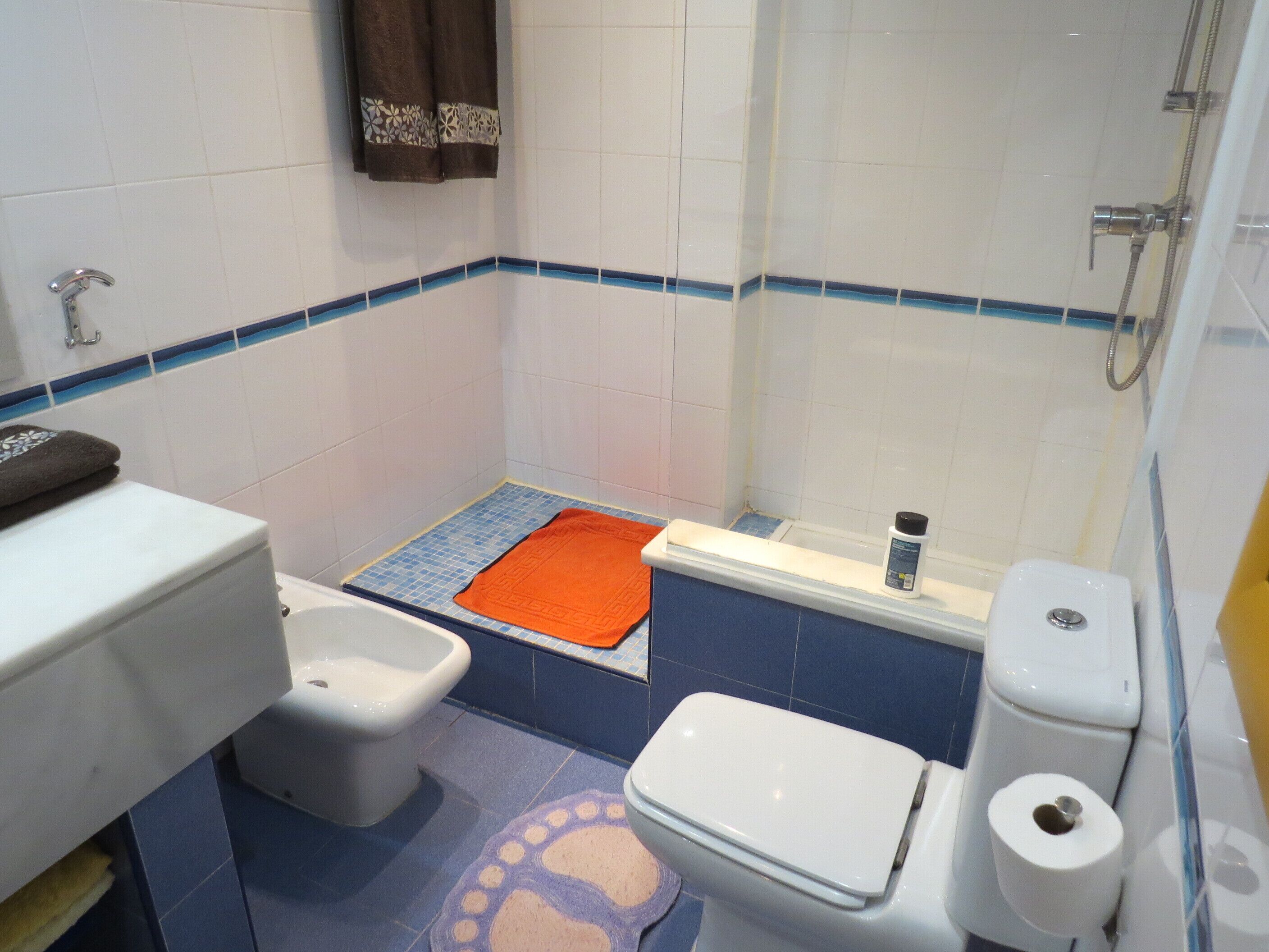 A small bathroom with a toilet, bidet, and shower.
