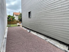 A building with a grey exterior and a gravel driveway.