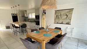 Ein moderner Essbereich mit einem Holztisch und grau gepolsterten Stühlen.