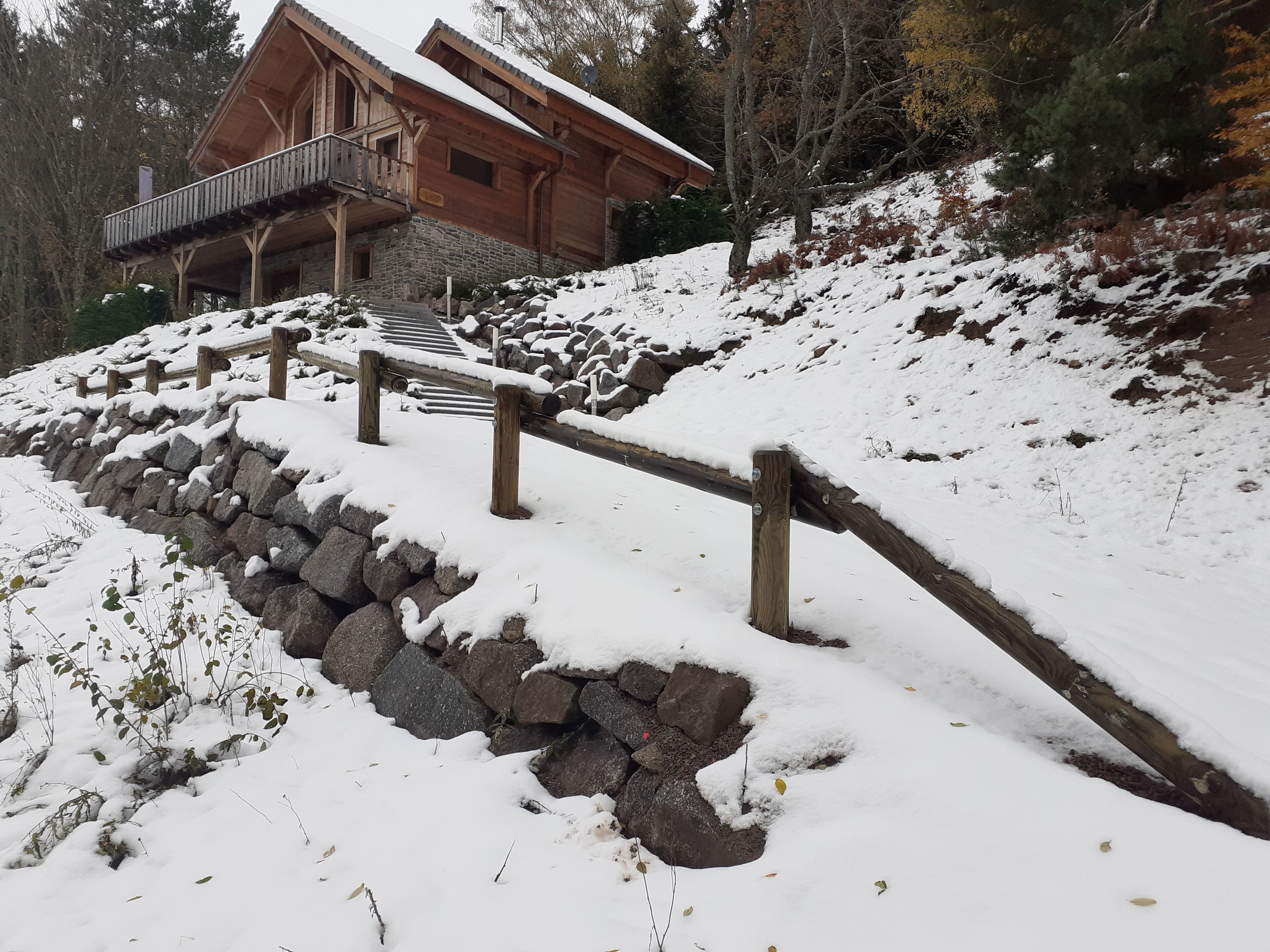 Eine Holzhütte mit einer Steintreppe, die zu einer Holzdiele führt.
