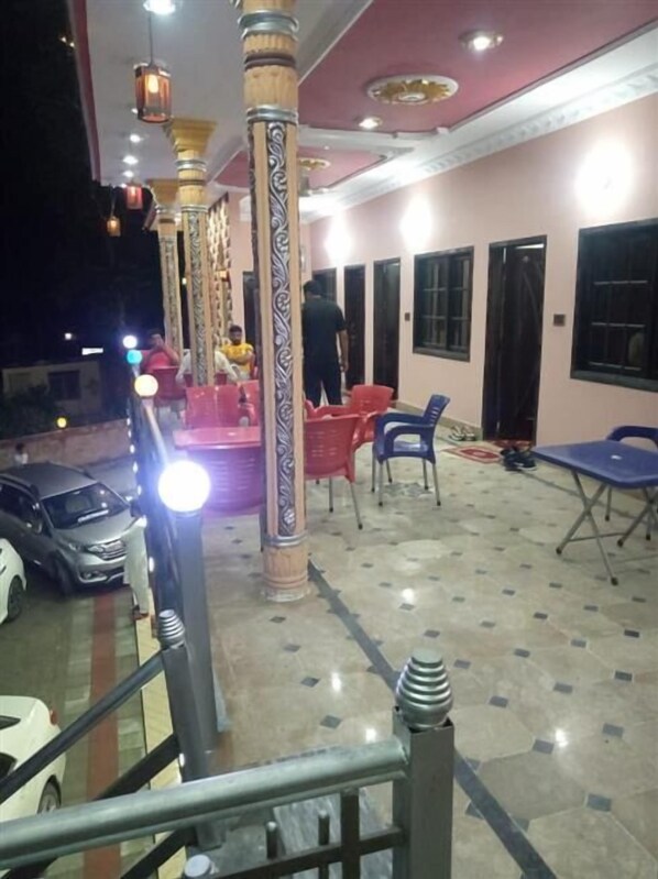 Un'area esterna coperta con posti a sedere e un'auto parcheggiata nelle vicinanze.