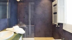 Un baño moderno con un espejo grande, ducha, bidé e inodoro.
