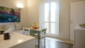 Una habitación luminosa con una mesa de comedor, sillas, un sofá y un ventanal grande.