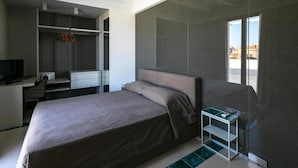 A modern hotel room with a large bed, a desk, a chair, and a TV. - Terrammare apartment (Trapani)