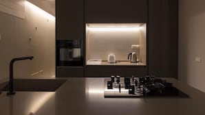 A modern kitchen with a built-in stove, a coffee machine, and a kettle. - Terrammare apartment (Trapani)