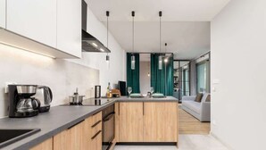 Una cocina moderna con una isla central, armarios de madera y encimera negra.