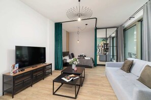 Ein modernes Wohnzimmer mit Flachbildfernseher, Couchtisch und Sofa.
