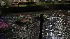 Een gebouw met meerdere verdiepingen, terras en een waterpartij ervoor.
