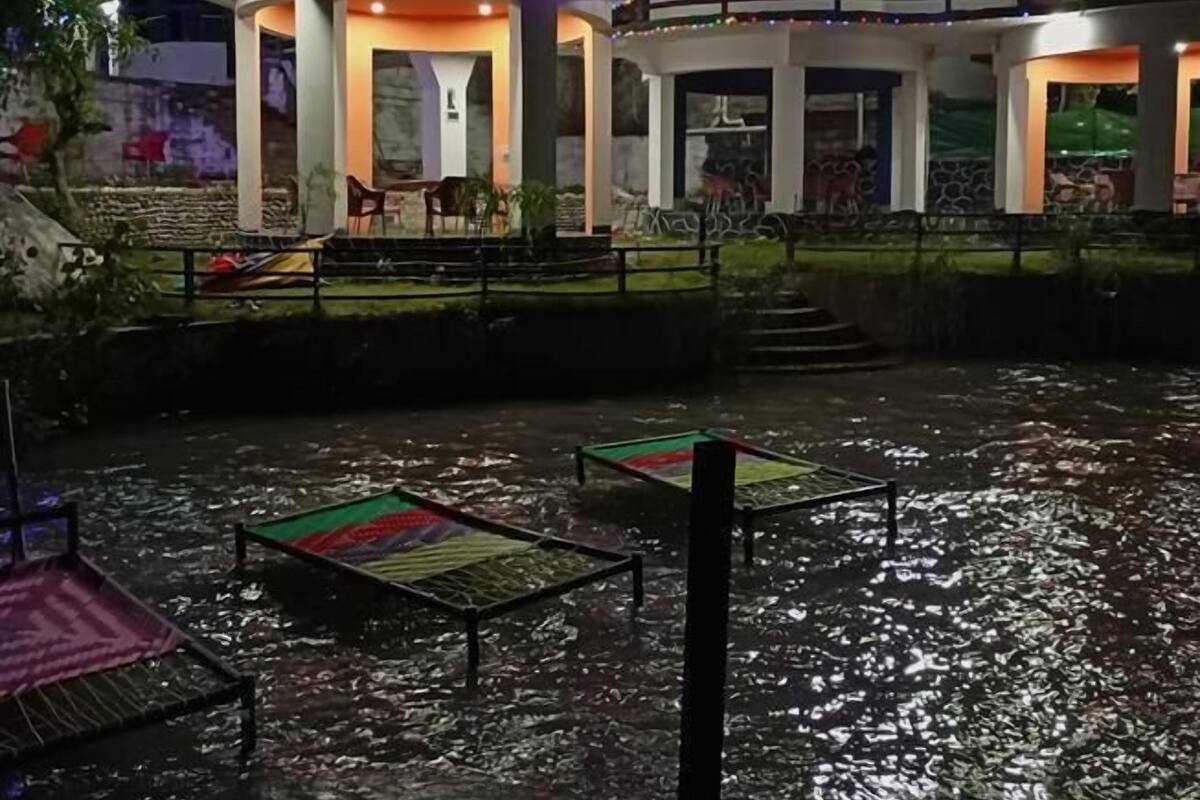 Een gebouw met meerdere verdiepingen, terras en een waterpartij ervoor.