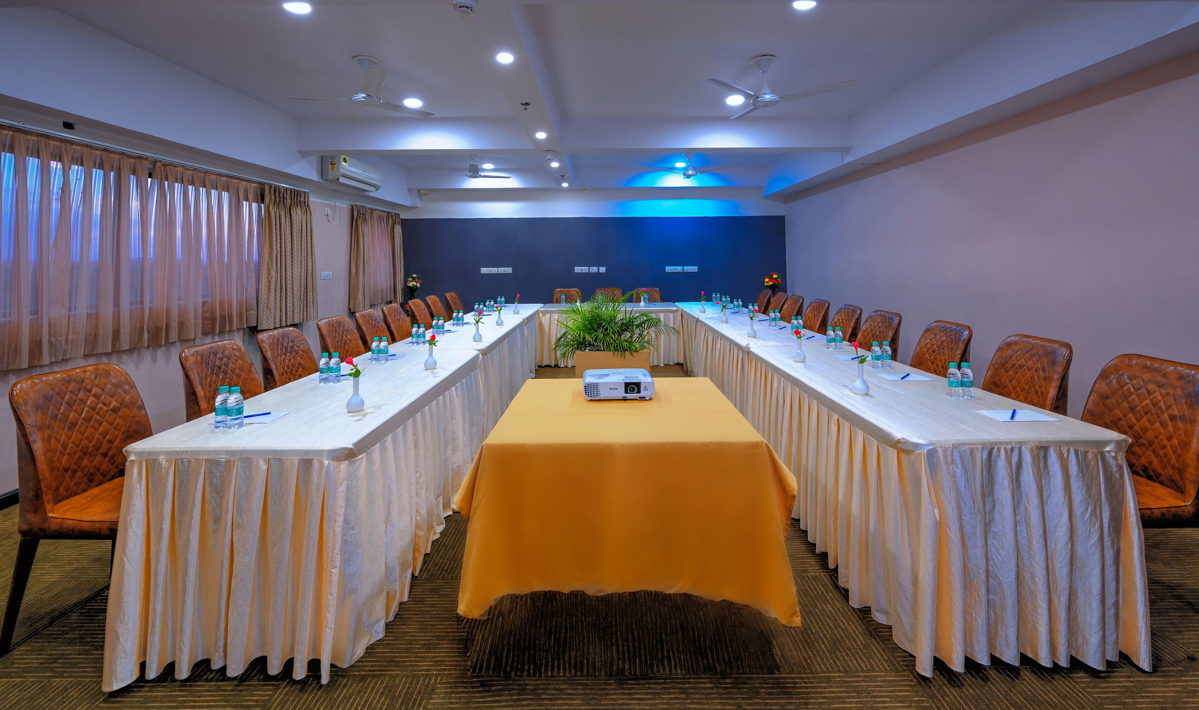 A conference room with a long table, chairs, and a projector.