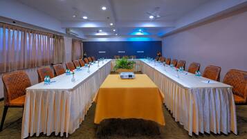 A conference room with a long table, chairs, and a projector.