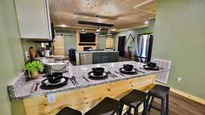 A kitchen with a wooden island, bar stools, a large refrigerator, and a built-in oven. - Best of the Smokies! •Game Room•GSMNP•Theater•Sleep 16•Hot Tub•Flat Parking (Sevierville)