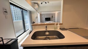 Un baño moderno con lavamanos, espejo y artículos de aseo.