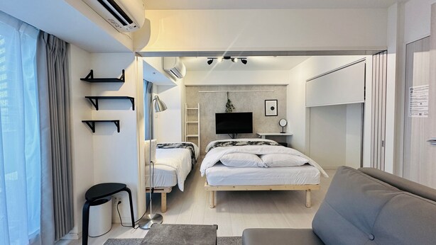 Una habitación de hotel moderna con cama, sofá, escritorio y televisor.
