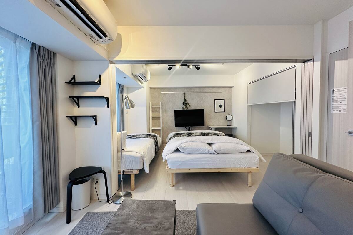 Une chambre d’hôtel moderne équipée d’un lit, d’un canapé, d’un bureau et d’une télévision.