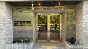 La entrada a un hotel con un cartel que dice 'Flower Terrace Higashishi Shinju'.
