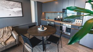A modern kitchen with a dining area, a sofa, and a large window with a city view. - Umhlanga Arch Luxury Holiday or Work with Sea View (Durban)