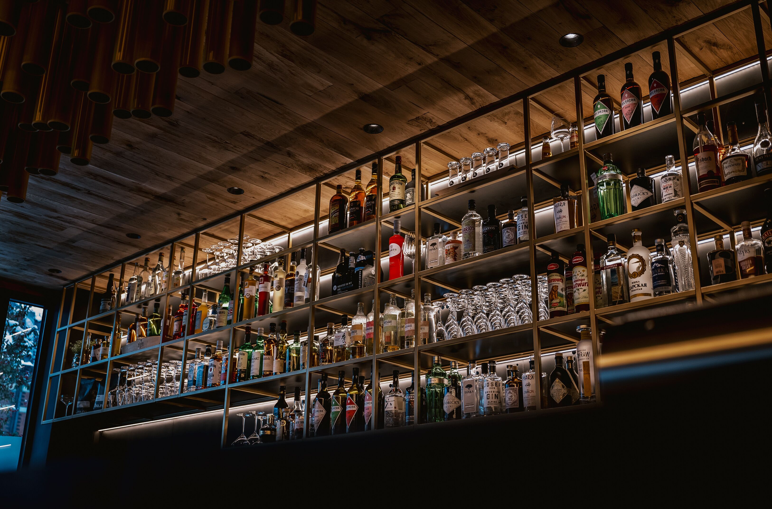 Eine Bar mit Regalen voller Spirituosenflaschen und Gläsern.