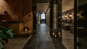 Un couloir moderne avec un mur en bois, un lavabo et un coin salon agrémenté de lampes.
