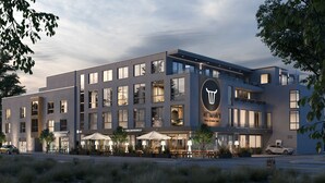 Un hôtel moderne doté d’un logo bien visible, d’une terrasse et d’une entrée bien éclairée.