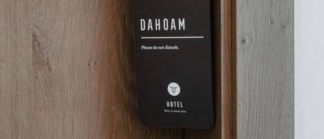 A black hotel door handle with the brand name "DAHOAM" and a note "Please do not disturb."