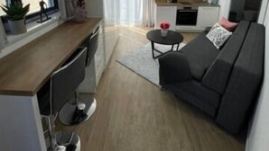 A compact living space with a kitchenette, a dining area, and a sofa. - Villa Laverna Annex (Novalja)