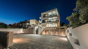 A modern multi-story residential building with a paved driveway and gated entrance. - Villa Laverna Annex (Novalja)