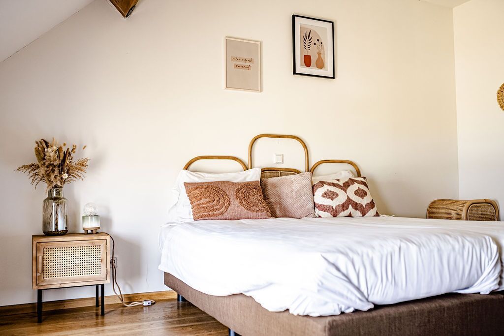 A bedroom with a bed, bedside table, and wall decorations.