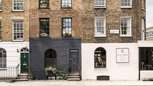 A two-story brick building with a black front door and windows. - Stunning townhouse with large roof terrace (London)