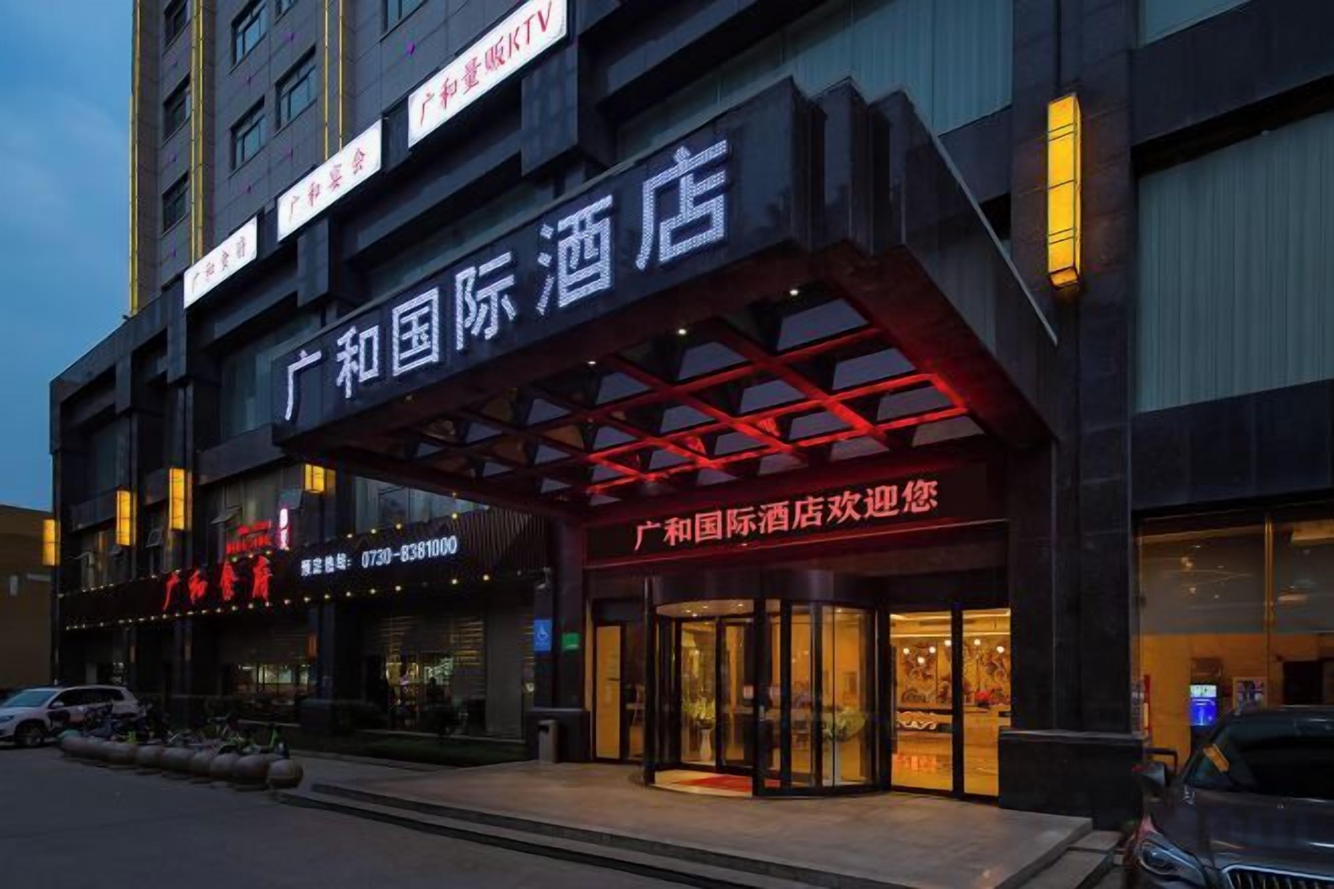 A hotel with a prominent entrance, signage, and a parking area.