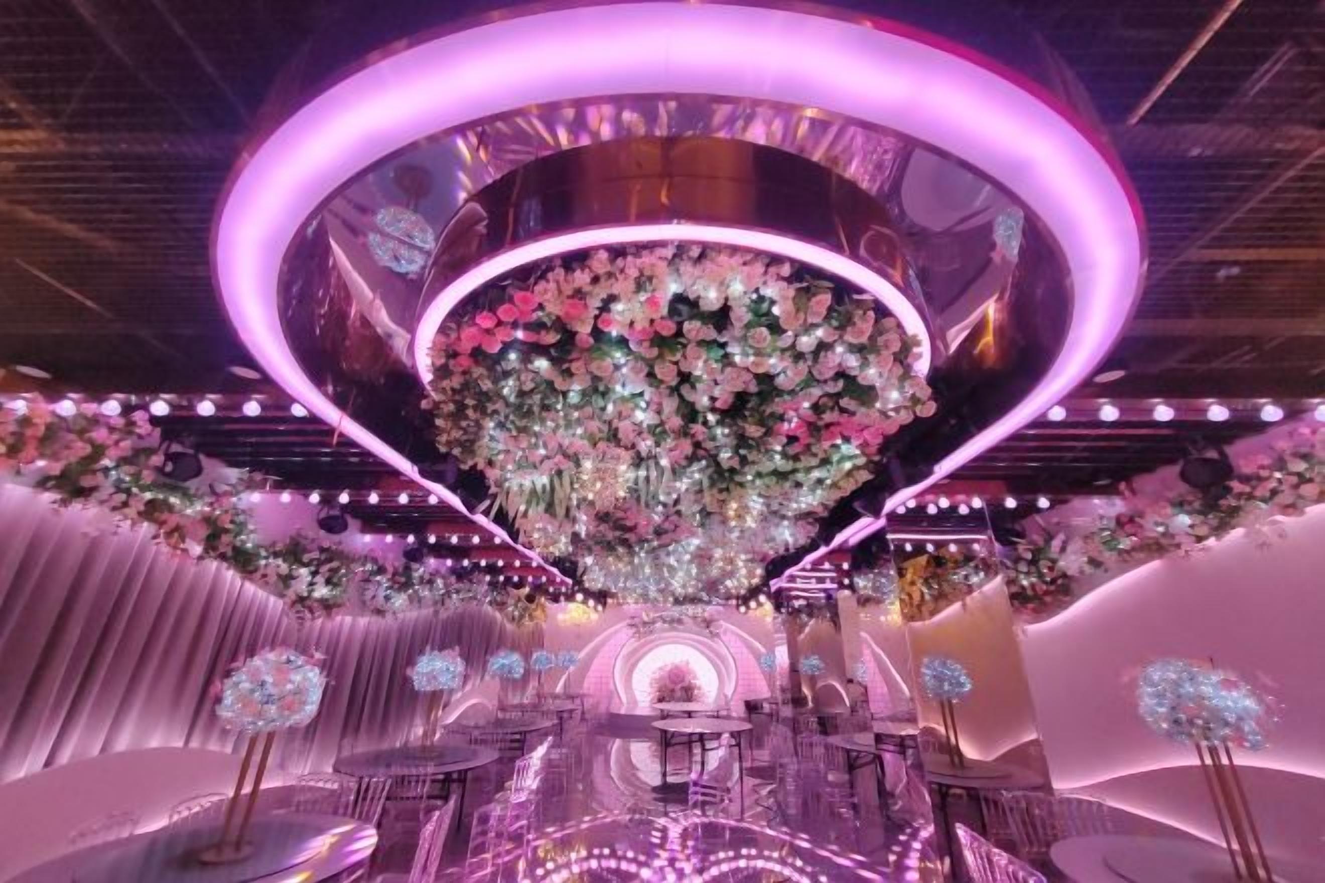 A stage with a central floral arrangement and a circular light fixture.