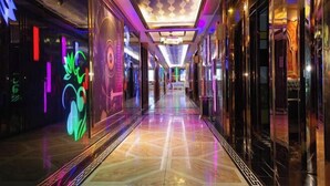 A corridor with reflective floors and walls adorned with colorful, abstract designs.