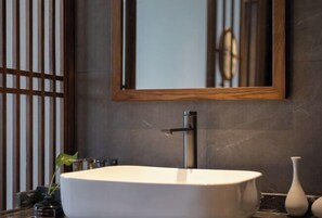 A modern bathroom with a large rectangular sink, a vertical faucet, and a mirror above it. - Guanghe International Hotel (Yueyang)