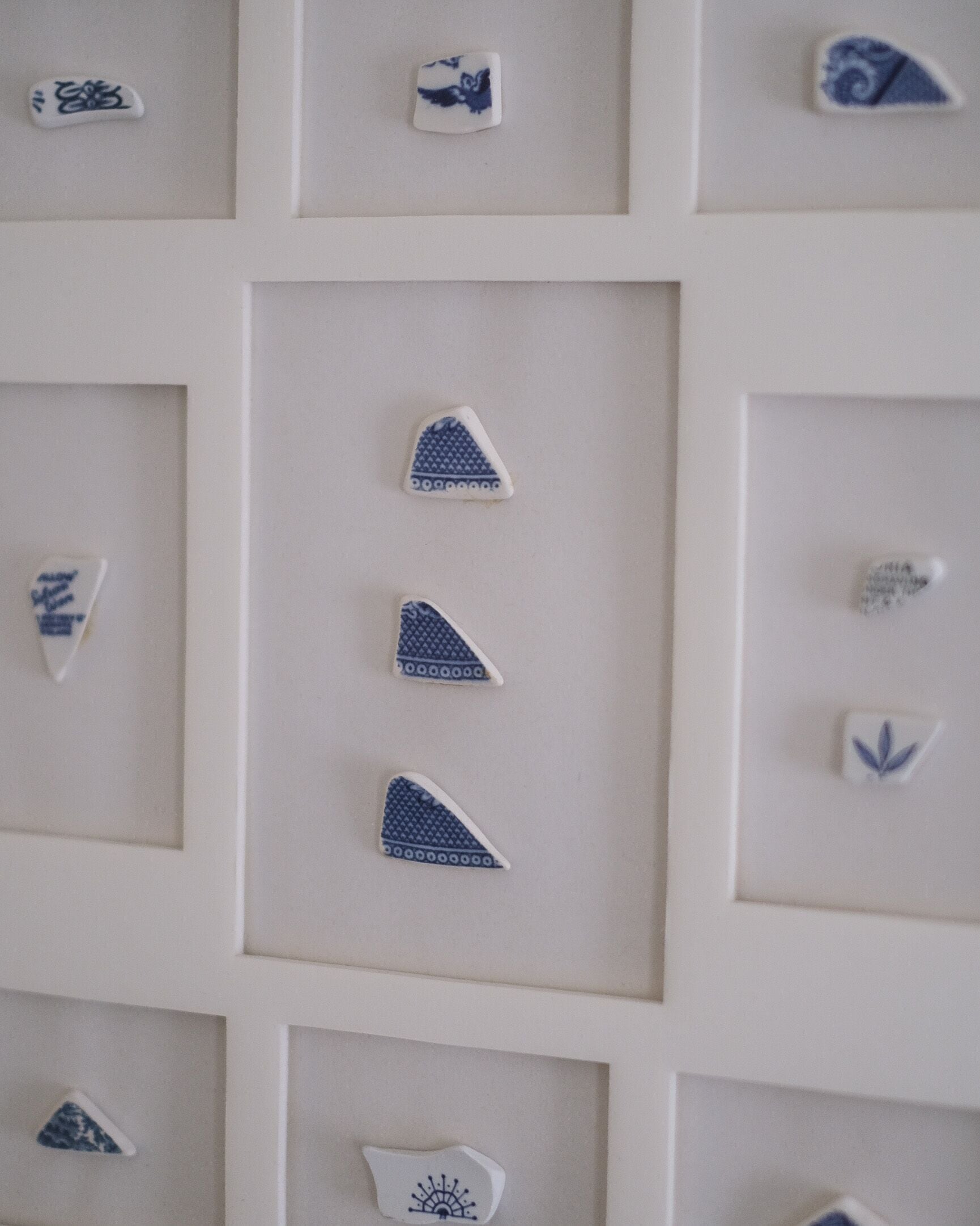 A wall with multiple framed tiles, each featuring different patterns and designs.