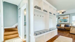A modern living room with a built-in bench, a sofa, and a ceiling fan. - Sandyland Shores - Screened Porch, Intracoastal & Sea Views! (Surfside Beach)