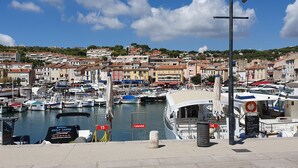 Puerto deportivo con barcos amarrados, un cartel que dice 'Bateau Ecole Cassis' y un cartel de 'Calend'.