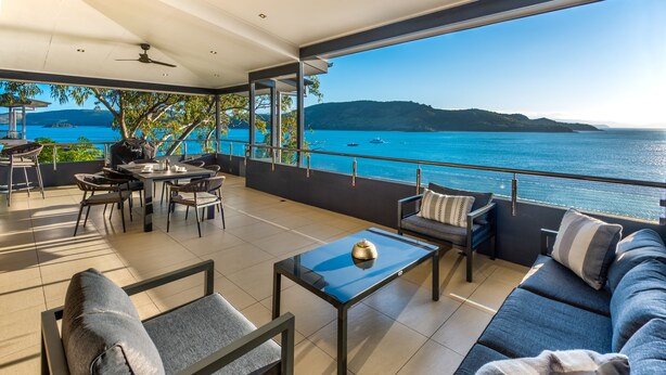 A spacious balcony with a view of the sea, furnished with a sofa, chairs, and a table. - Edge Apartment 7, Edge Apartment 7 by HIHA (Hamilton Island)