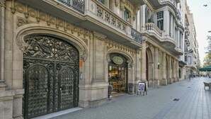 A historic building with ornate iron gates and a boutique hotel entrance.